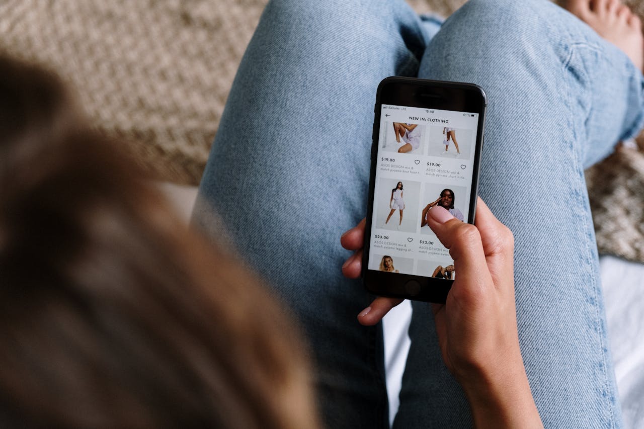 Mastering the First Impression: Your intriguing post title goes here A woman uses her smartphone to shop for clothing online, showcasing digital retail technology.